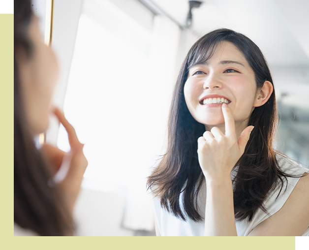 鏡の前で歯のチェックをしている女性